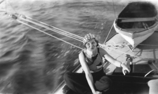 Kvinna vid en segelbåts rodder